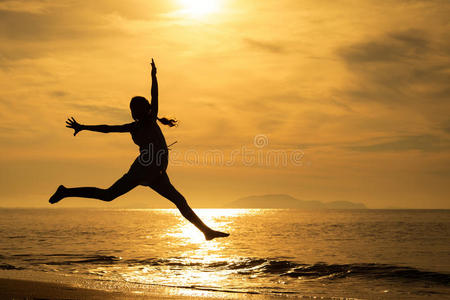 快乐的女孩在海滩上跳跃
