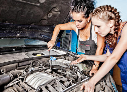 两个女汽车修理工在修理一辆汽车