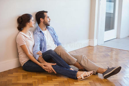 一对可爱的夫妇坐在地板上靠墙