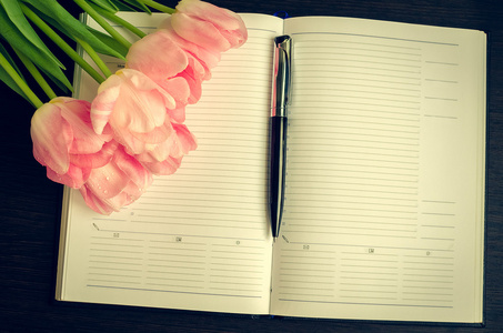 美丽的粉红色郁金香与笔记本