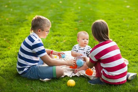 快乐的孩子们在夏天公园的绿色草地上。健康的生活方式