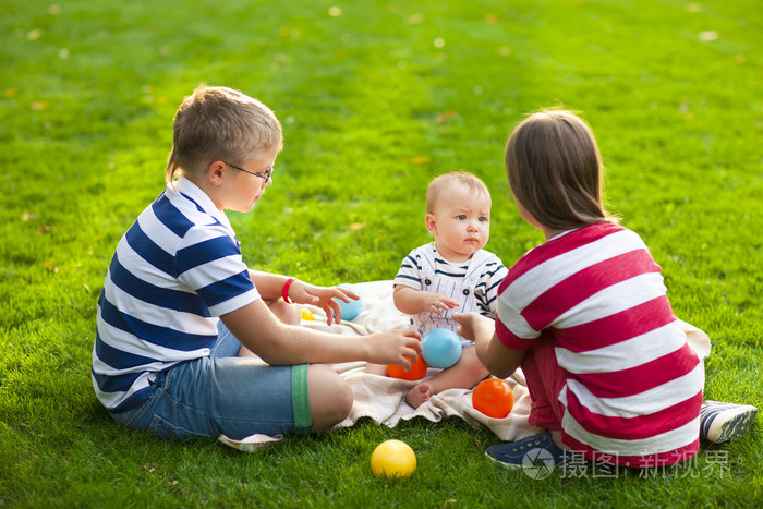 快乐的孩子们在夏天公园的绿色草地上。健康的生活方式