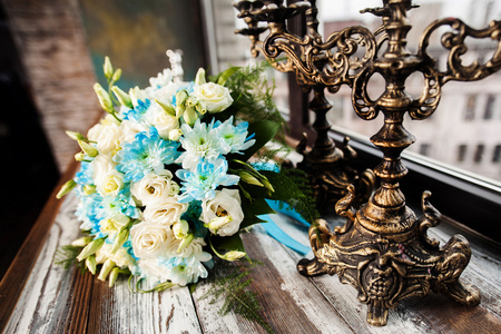 与老式烛台木制的桌子上的美丽婚礼花束