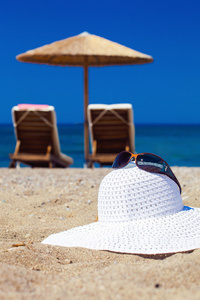 蓝色的大海和沙滩上的帽子颜色