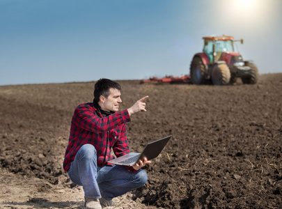 农民在农田上的笔记本电脑