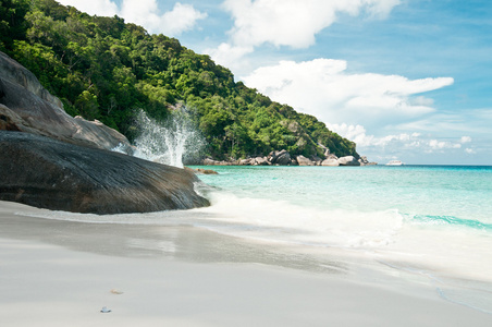 在热带的白色沙滩，岩石 森林 天空和海浪打在岩石上的视图。普吉岛，泰国普吉岛