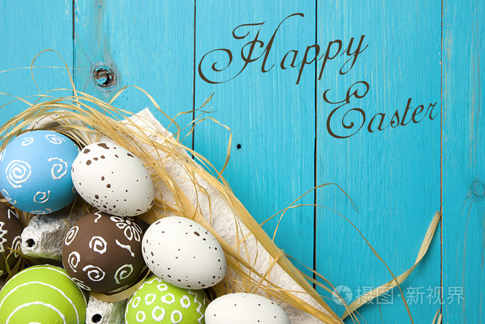 复活节贺卡.涂上蓝色的木制背景与副本空间为祝贺鸟巢中的复活节彩蛋