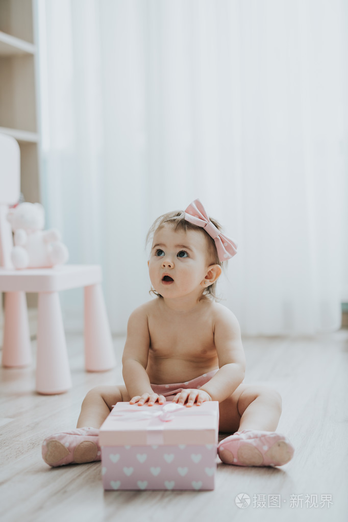 可爱的小宝贝女孩早晨用玩具在白色的房间里玩
