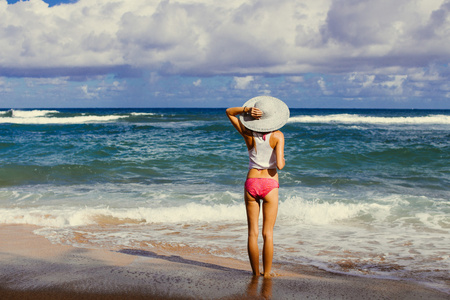女孩在沙滩上看着大海，夏威夷