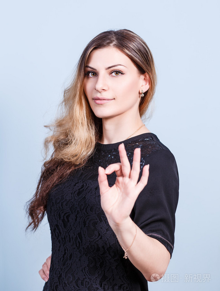 年轻漂亮的女人显示 ok 的手势