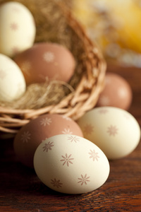 复活节彩蛋和柳条篮子，木制的桌子上
