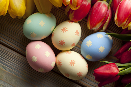 复活节彩蛋和木制背景上的花朵