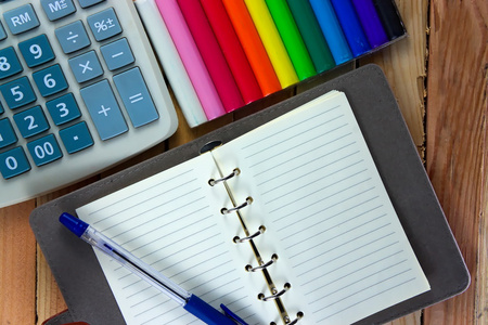 在顶视图上看到的颜色铅笔和笔记本木制的桌子上