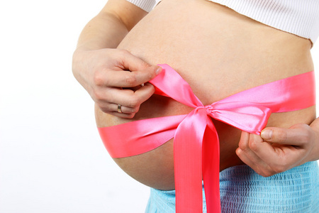 腹中怀孕的女孩与一个粉红色的蝴蝶结