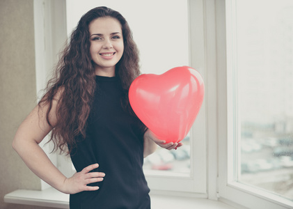 美女握握着气球心脏的白种人美女照片