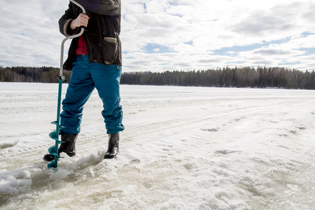 使用一个孔在湖上的冰渔夫演习
