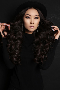 的亚裔女子，和一头乌黑的长发，穿着黑色连衣裙