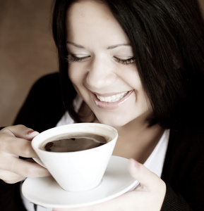年轻女子坐在一家咖啡馆喝咖啡