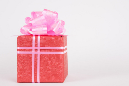 带着弓和粉红丝带红色礼品盒