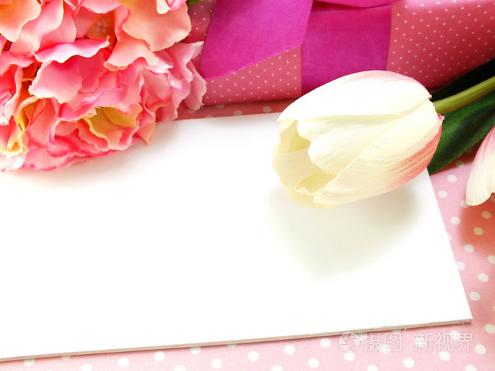 白的礼品卡和郁金香人造花粉红色背景