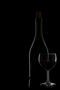 瓶酒和一杯红酒在黑色的背景，最小值