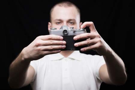 严重的年轻人拍摄自己在一个老式的相机上