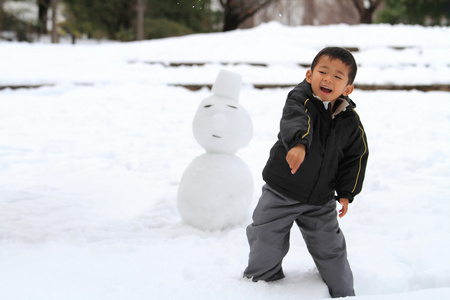 打雪仗和堆雪人的日本男孩4岁