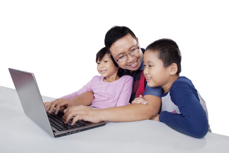 年轻男子与他的孩子们使用笔记本电脑
