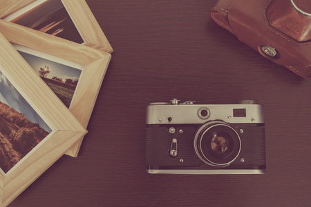 复古老式相机和木背景帧中的照片
