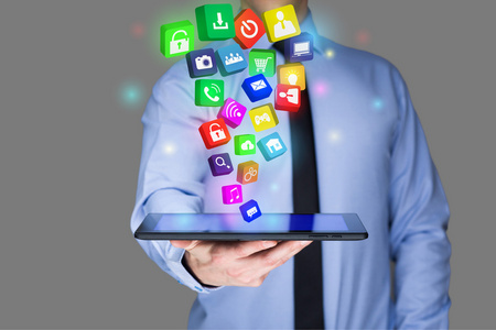 商人在虚拟屏幕上持有一台 tablet pc 与移动应用程序图标。互联网和业务概念