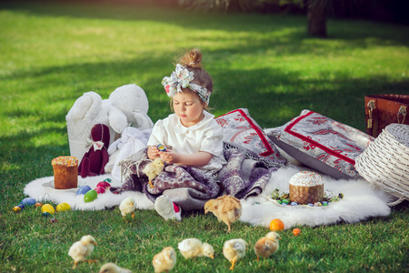 孩子坐在复活节装饰附近的草地上
