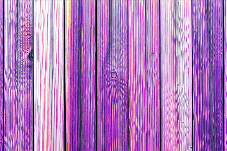 古老的木栅栏的一个片段。作为一个与副本空间背景画木板。木制仿古背景或漆过的木头板纹理。老紫色油漆剥落