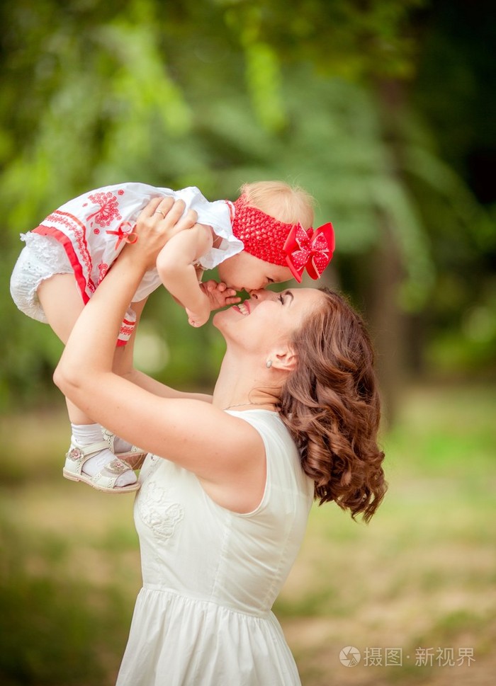 母亲带着宝贝女儿在春天的花园