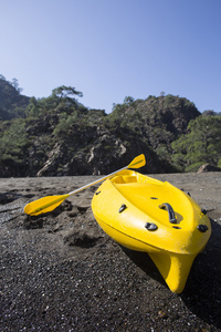 Kayak 是在山上的背景下的海滩上