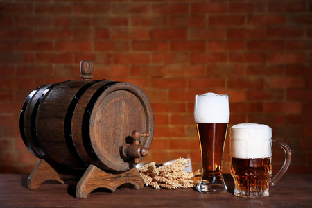 眼镜杯淡啤酒用木桶和大麦耳朵上砖的墙背景