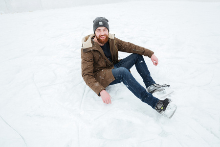 男子坐在雪地里溜冰鞋