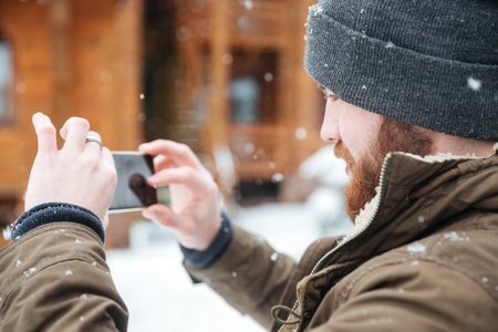 在下雪的天气用手机拍照的人