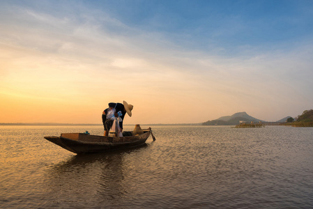 亚洲渔民在船上准备在日出前清晨在自然河捕淡水鱼网