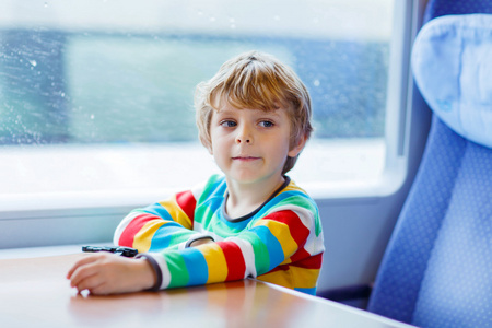 坐在火车上度假的小男孩