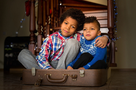 两个男孩坐在里面的手提箱