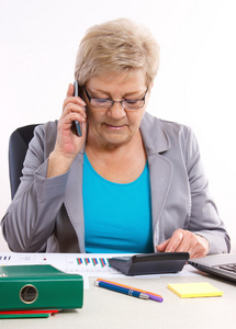 一位年长的商务女性，在手机上说话，在他工作
