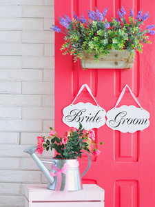 新娘和新郎挂在房门上粉红色的装饰板