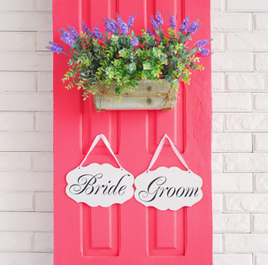 新娘和新郎挂在房门上粉红色的装饰板