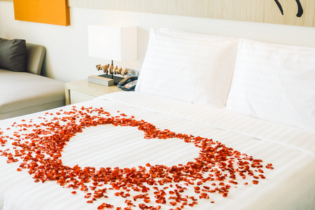 在床上和玫瑰花瓣上的白色枕头