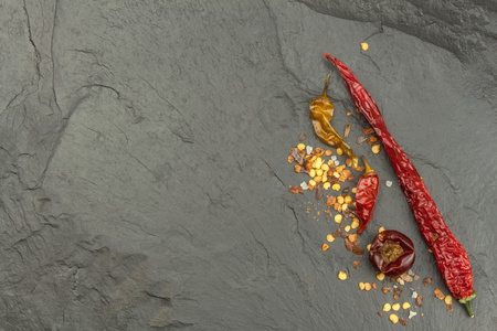 干的辣椒在黑暗的石板上。辣的食物的强烈香料。装修厨房。您的文本的的地方。创建菜单