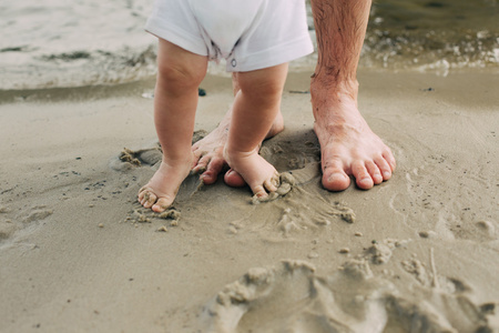 光着脚的父亲和他的小儿子住在附近的水沙