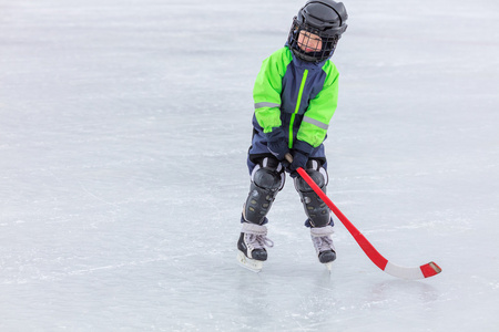 小男孩滑冰和打曲棍球