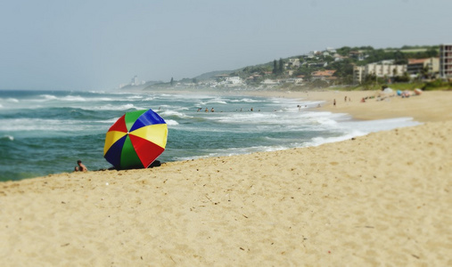 在一个阳光明媚的海滩海洋上的花伞