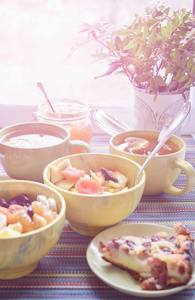 麦片糊 水果 蛋糕和茶一起吃早餐。彩色桌布上
