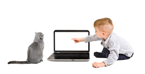 孩子点手指在屏幕上的笔记本和一只猫坐着